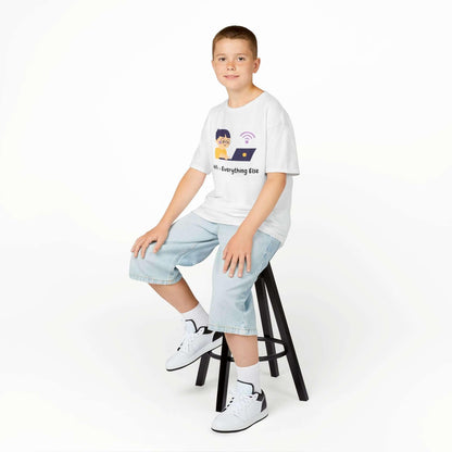 Young boy wearing a "Wifi Greater Than Everything" funny T-shirt, sitting on a stool, showcasing a comfortable kids' cotton tee.