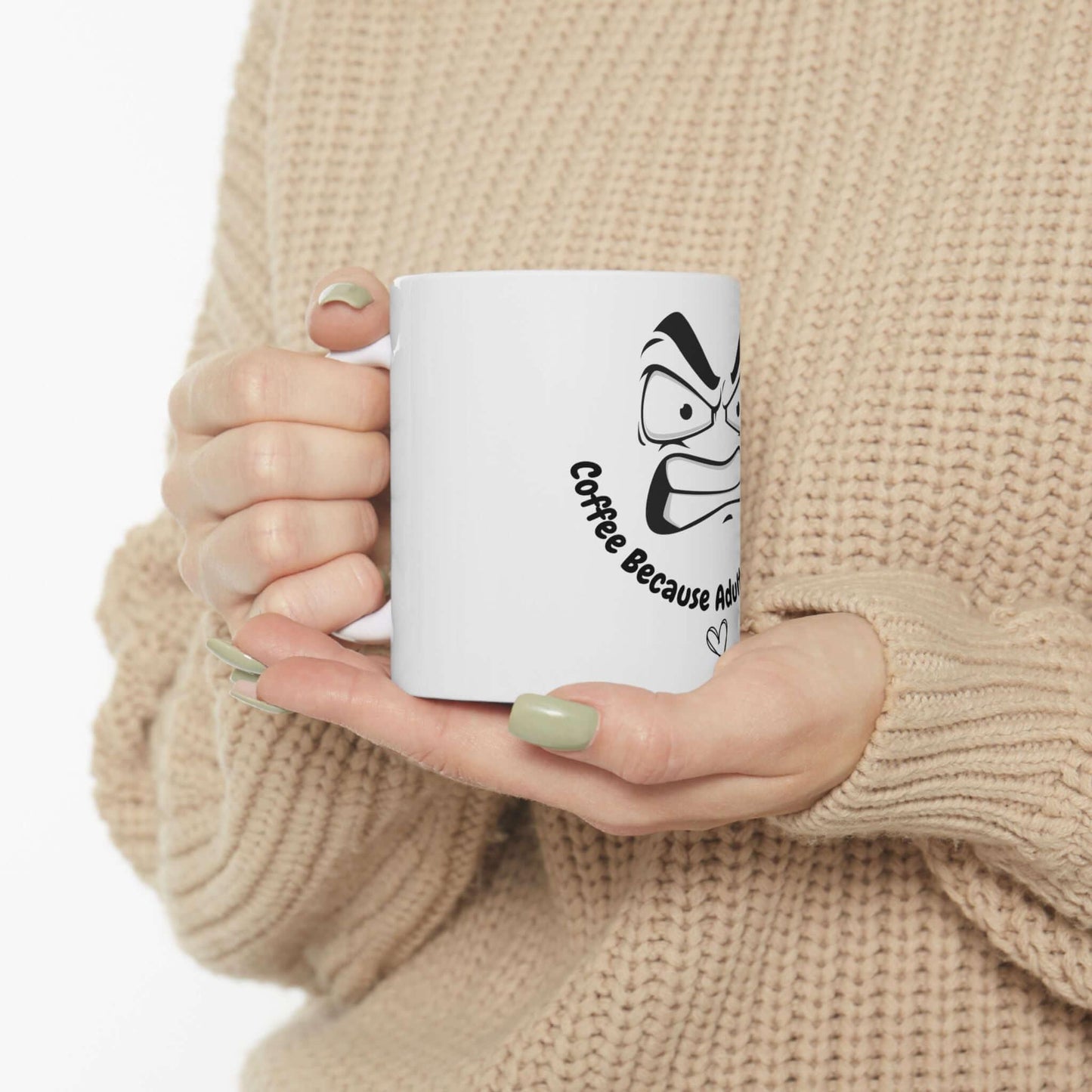 Person holding a white ceramic mug with funny design and text 'Coffee because adulting is hard,' perfect gift idea.