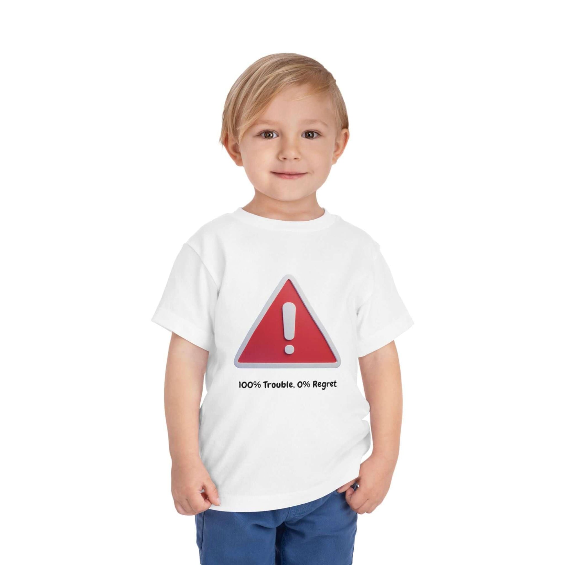 Toddler wearing a white short sleeve tee with red warning sign and text '100% Trouble. 0% Regret'. Perfect for casual everyday wear.